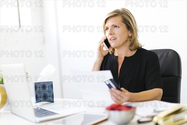 Displeased Mature woman paying bills