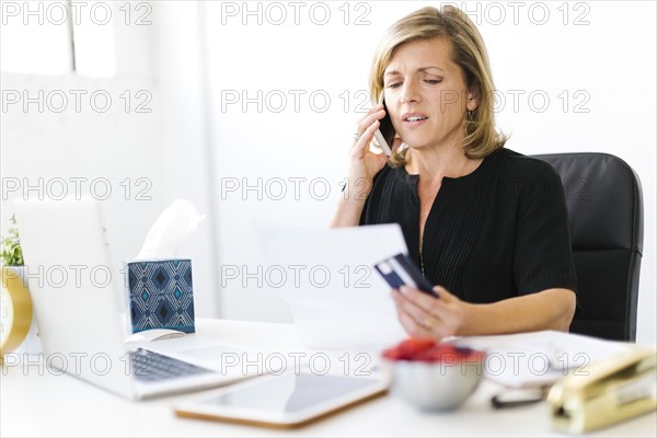 Displeased Mature woman paying bills