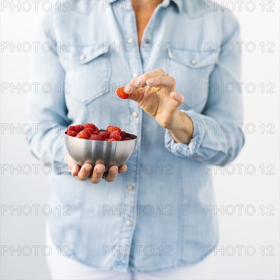 Woman holding bowl of raspberries