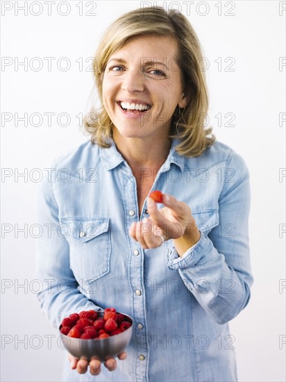 Woman holding bowl of raspberries