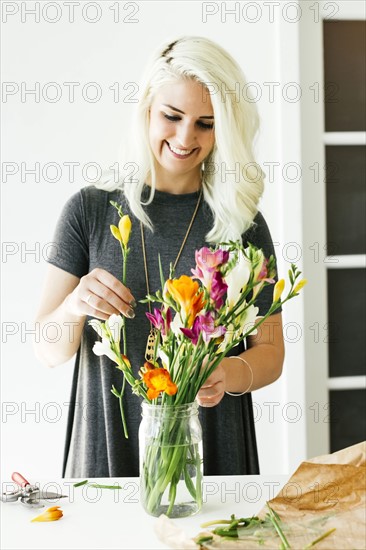 Woman putting flowers into jar