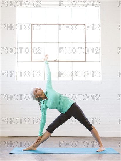 Senior woman practicing yoga on mat