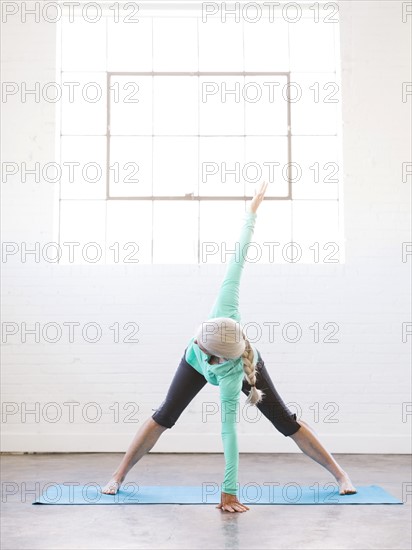 Senior woman practicing yoga on mat