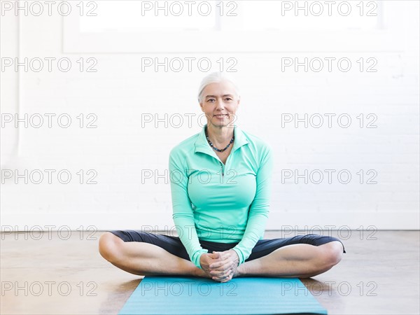 Senior woman practicing yoga on mat