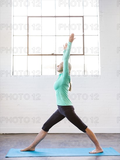 Senior woman practicing yoga on mat