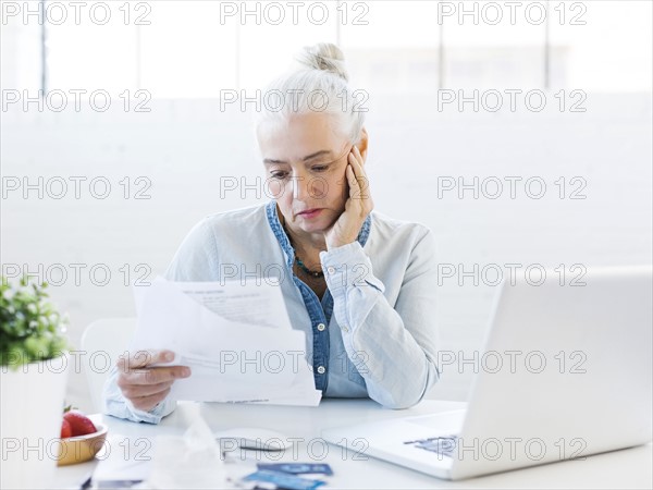 Senior woman paying bills