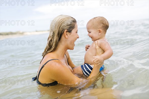 Mother playing with son (12-17 months) in sea