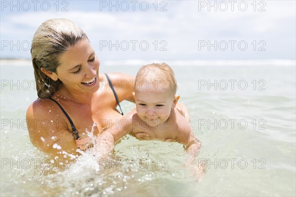 Mother playing with son (12-17 months) in sea