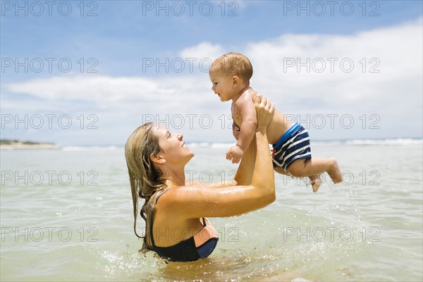 Mother playing with son (12-17 months) in sea