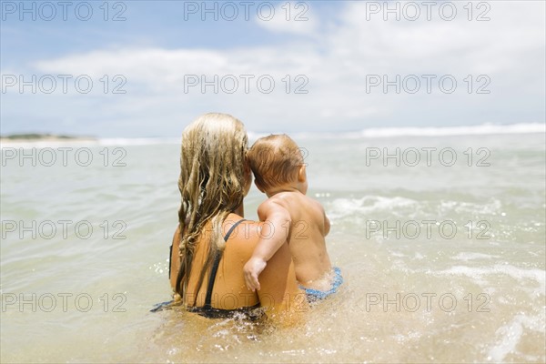 Mother playing with son (12-17 months) in sea