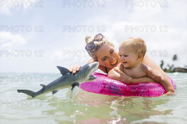 Mother playing with son (12-17 months) in sea