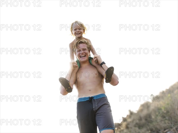 Young man carrying brother on shoulders