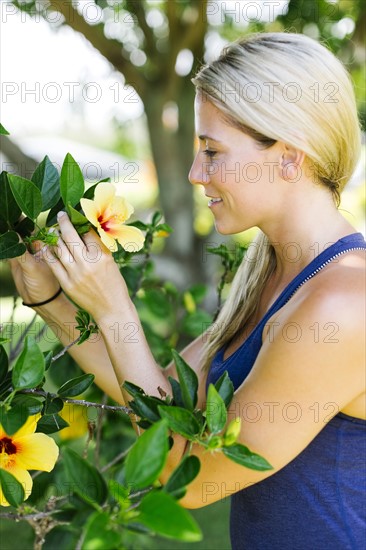 Blonde beautiful woman picking flowers