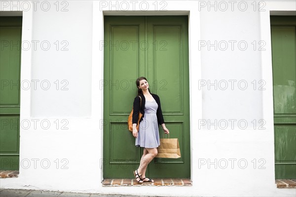 Puerto Rico, San Juan, Woman with shopping bag walking city streets