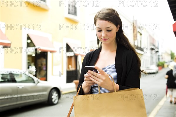 Puerto Rico, San Juan, Woman with shopping bag walking in city street