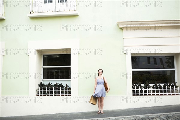 Puerto Rico, San Juan, Woman with shopping bag walking city streets