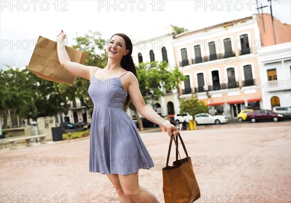 Puerto Rico, San Juan, Woman with shopping bag walking city streets