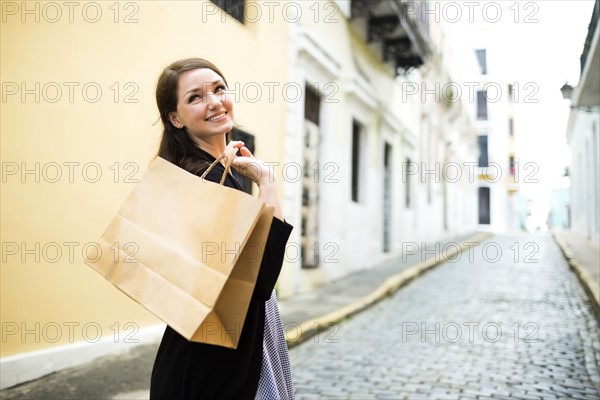 Puerto Rico, San Juan, Woman with shopping bag walking city streets