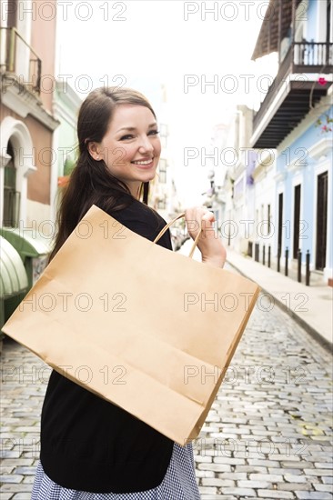 Puerto Rico, San Juan, Woman with shopping bag walking city streets