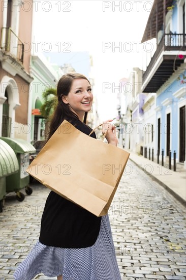 Puerto Rico, San Juan, Woman with shopping bag walking city streets