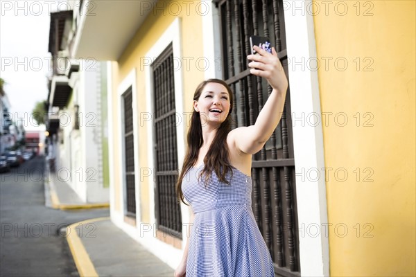 Puerto Rico, San Juan, Beautiful woman doing selfie on city street