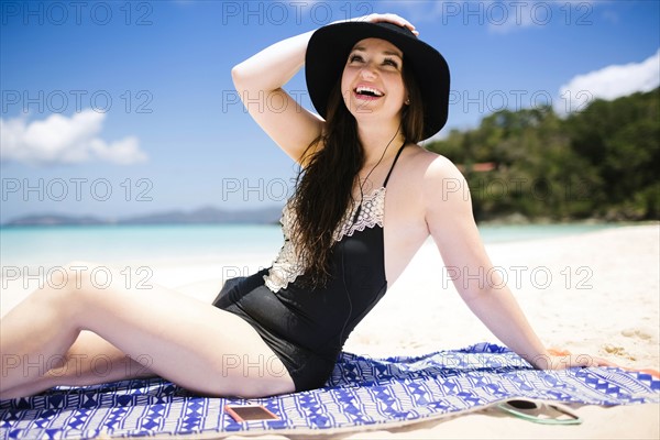 USA, Virgin Islands, Saint Thomas, Cheerful woman sitting on towel on beach
