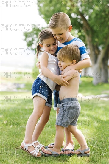 Siblings (2-3, 4-5, 6-7) embracing in park