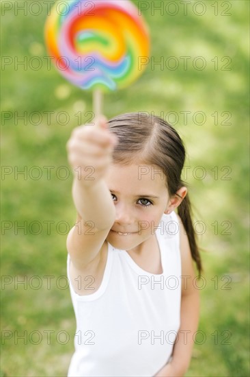 Girl (4-5) holding colorful lollipop