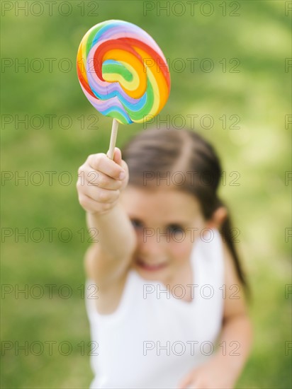 Girl (4-5) holding colorful lollipop