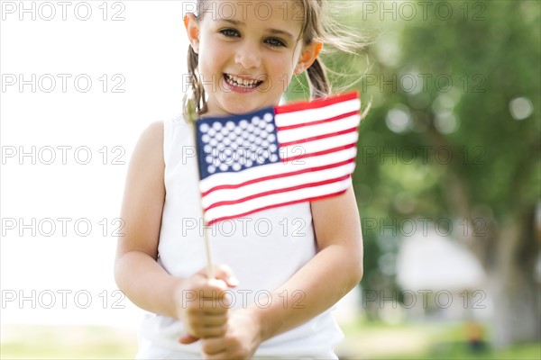 Girl (4-5) holding american flag