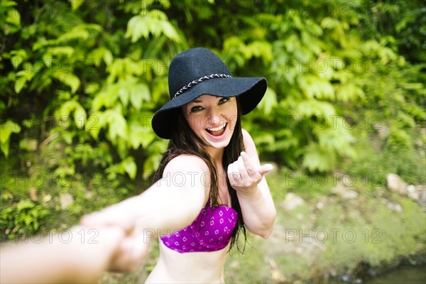 Woman holding person's hand and looking at camera