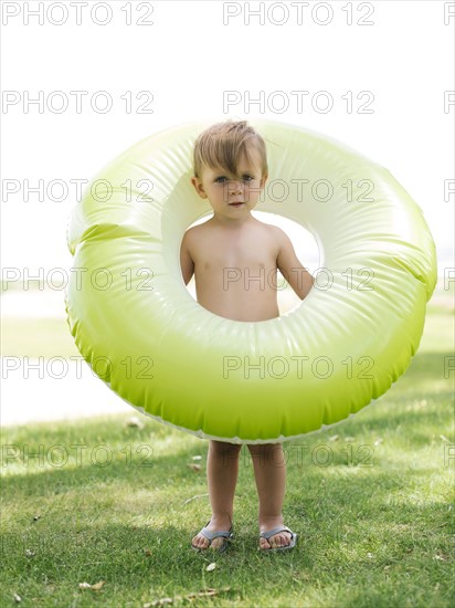 Boy (2-3) standing with inflatable ring