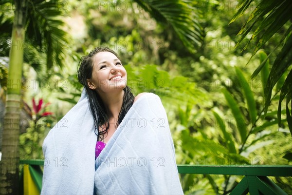 Caribbean Islands, Saint Lucia, Woman with wet hair wrapped in towel with lush foliage in background