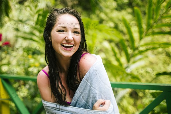 Caribbean Islands, Saint Lucia, Woman with wet hair wrapped in towel with lush foliage in background