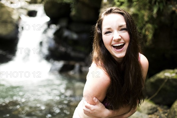 Caribbean Islands, Saint Lucia, Women by waterfall bending and hugging self