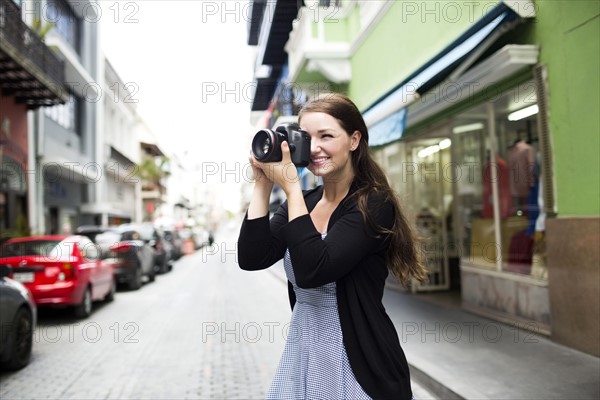 Puerto Rico, San Juan, Woman photographing buildings on street