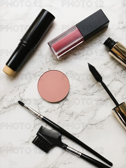 Lip sticks and mascara on marble background