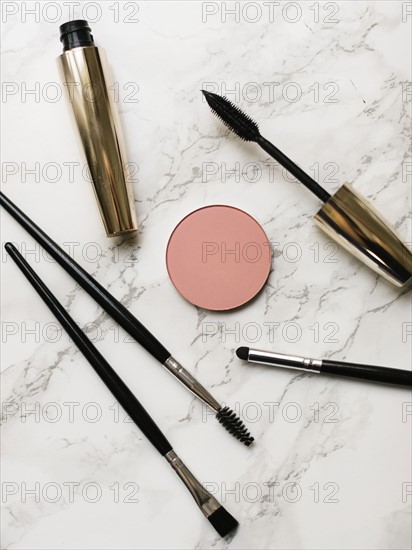 Mascara and make-up brushes on marble background