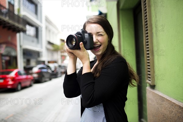 Puerto Rico, San Juan, Woman standing on street and photographing