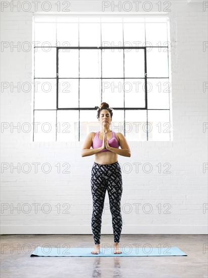 Woman practicing yoga on exercise mat