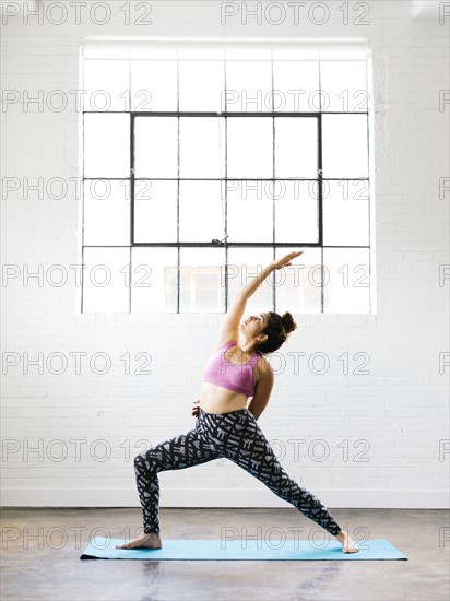 Woman practicing yoga on exercise mat