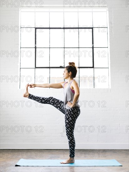 Woman practicing yoga on exercise mat