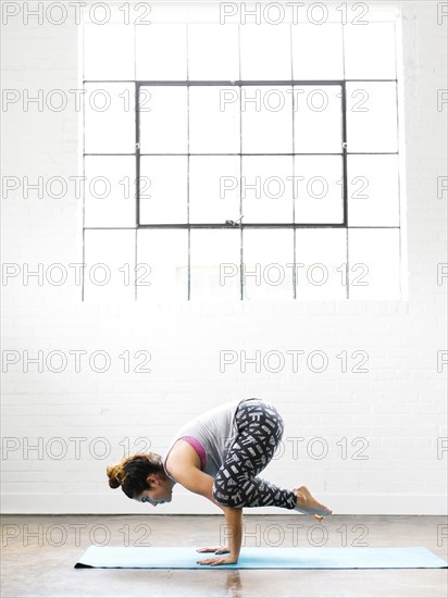 Woman practicing yoga on exercise mat