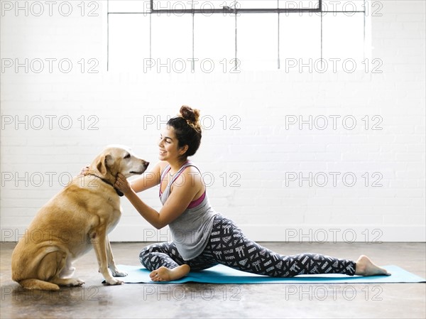 Woman practicing yoga with dog