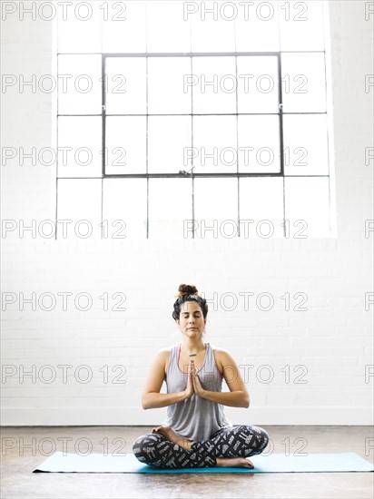 Woman meditating on exercise mat