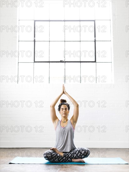 Woman meditating on exercise mat