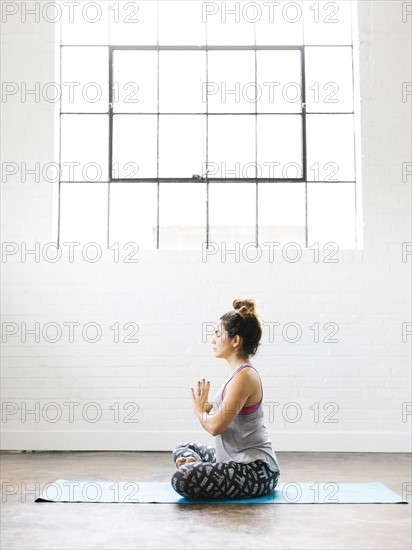 Woman meditating on exercise mat