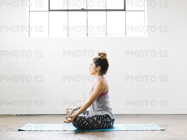 Woman meditating on exercise mat