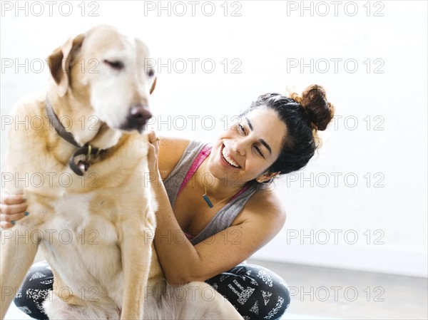 Woman practicing yoga with dog