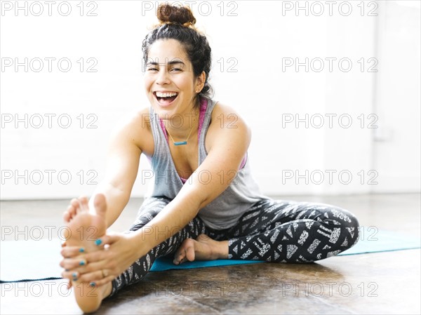 Portrait of woman stretching on exercise mat